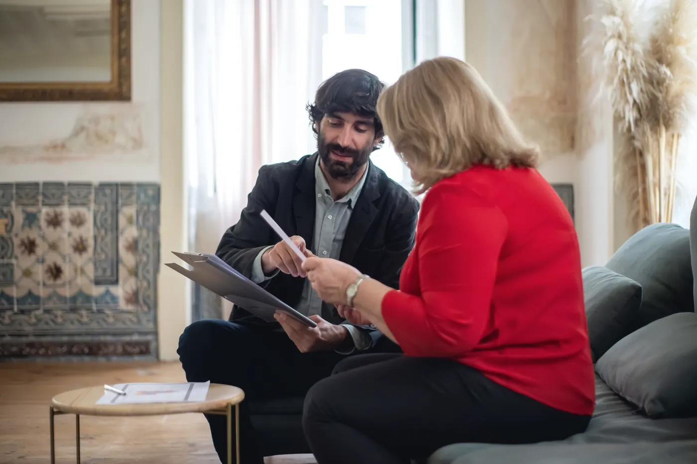 Conseiller et cliente qui consultent un dossier dans un salon