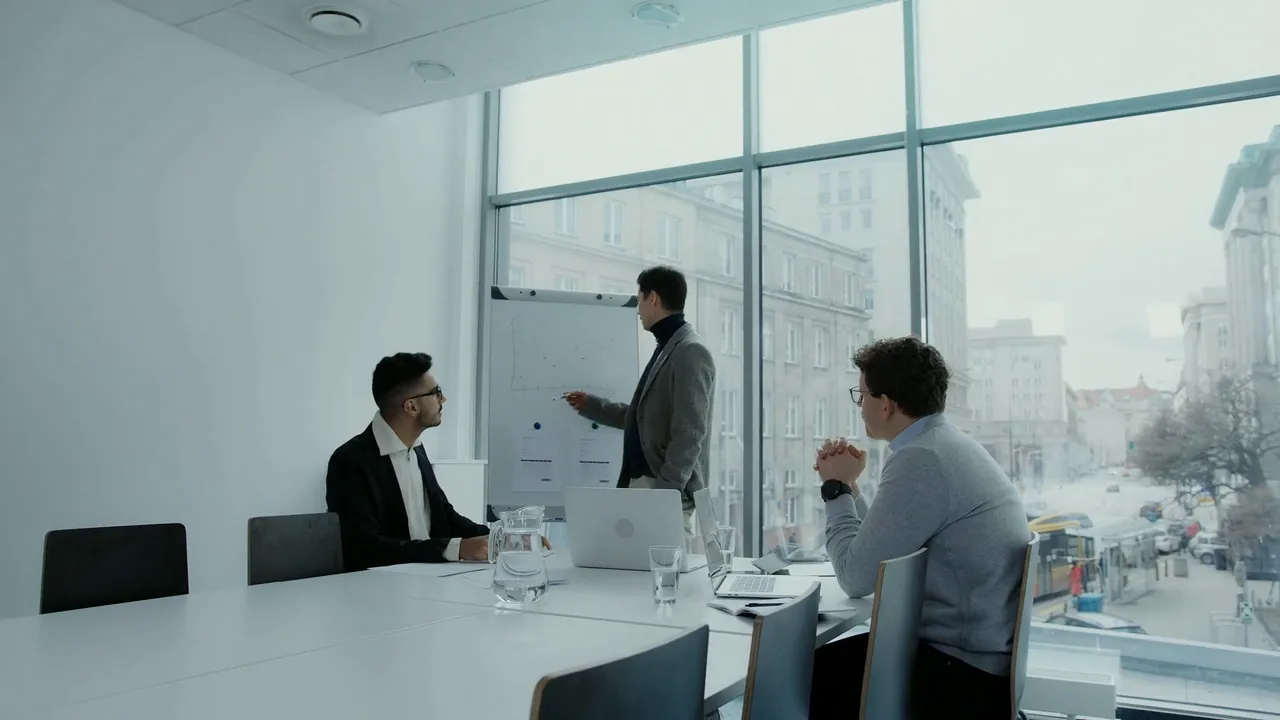 Séance de travail autour d'un tableau blanc dans une salle de réunion vitrée